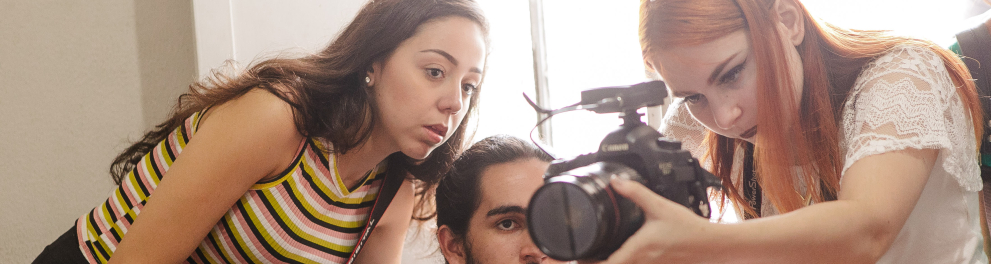 Jovens em volta de uma câmera