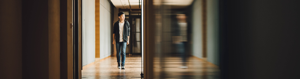 Um jovem andando no corredor de uma escola