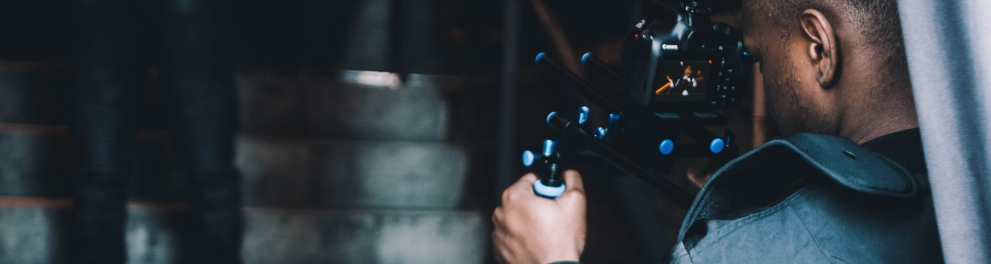 Um rapaz negro está operando uma máquina de filma